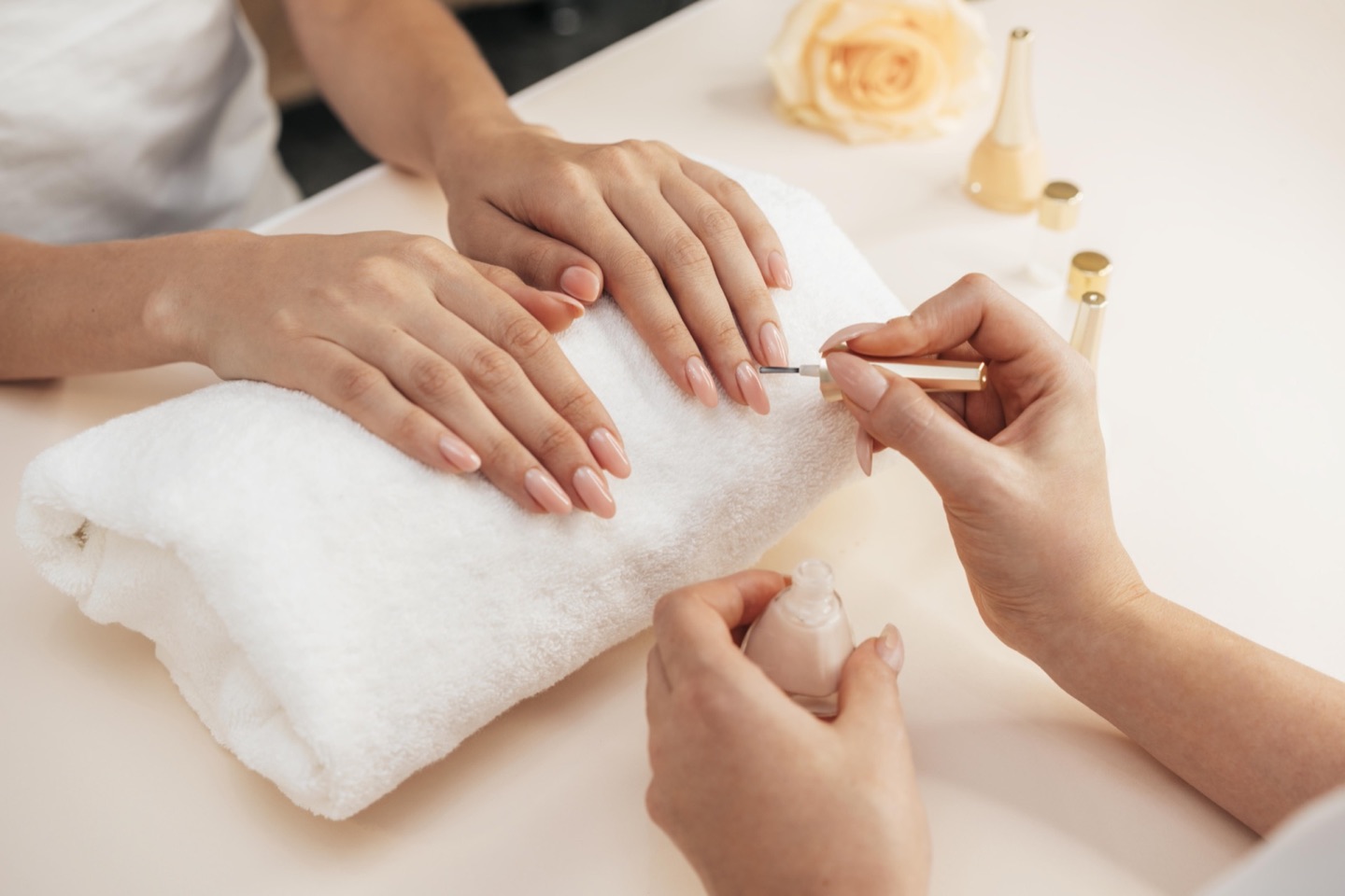 Manicurist working on healthy, sculpted nails during a manicure